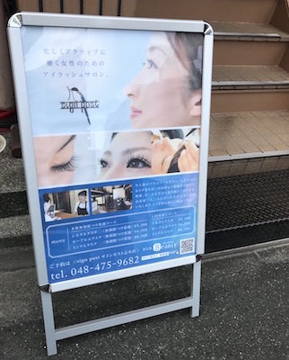 マツエクサロンの店頭看板のアップ。デザインや料金が見える